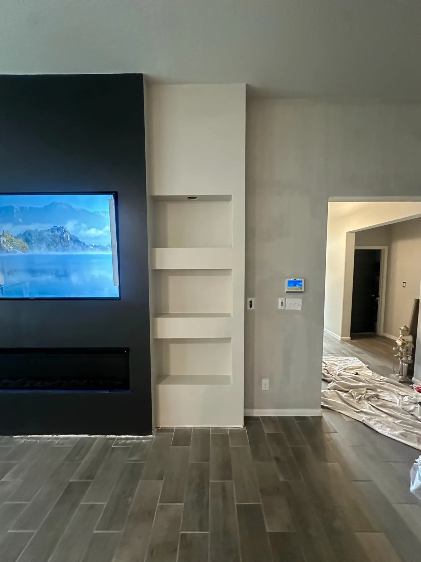 Finished custom media wall with built-in shelving and accent lighting